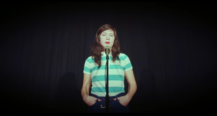 A photo still of Lucy Dacus looking straight into the camera from the music video of I Don't Want to be Funny Anymore.