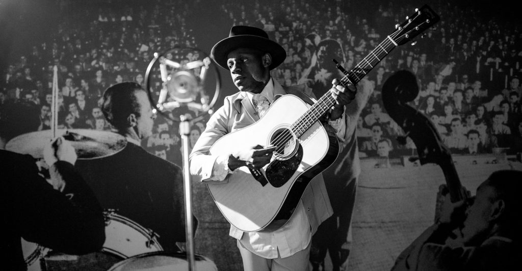 A black and white photo still of Ondara playing the guitar during the music video for Torch Song.