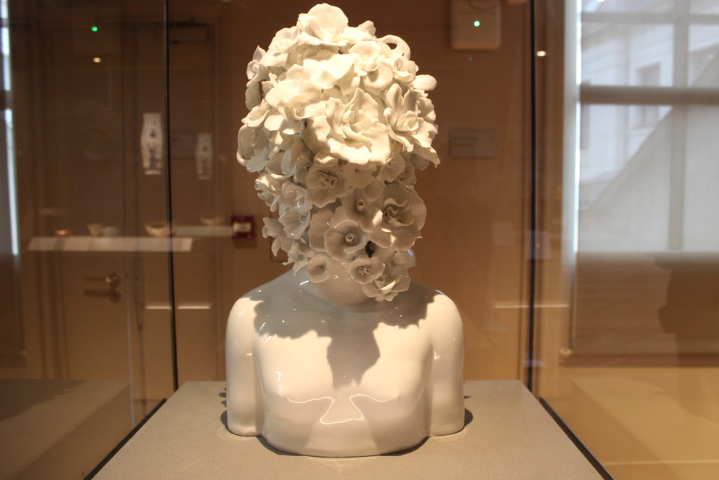 A photo of Youth, by Ru Xiao Fan. A porcelain bust where the head is replaced by a large bouquet of flowers.