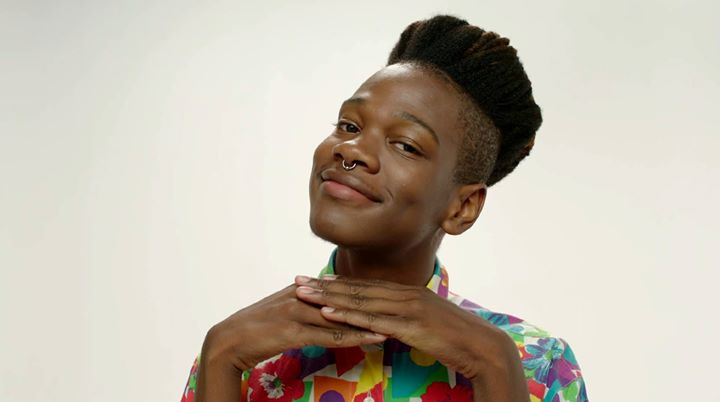 A photo still of Shamir smiling directly into the camera from the video for On the Regular.