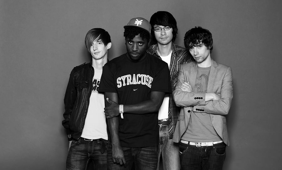 A promotional photo of the four band members of Bloc Party staring straight into the camera.