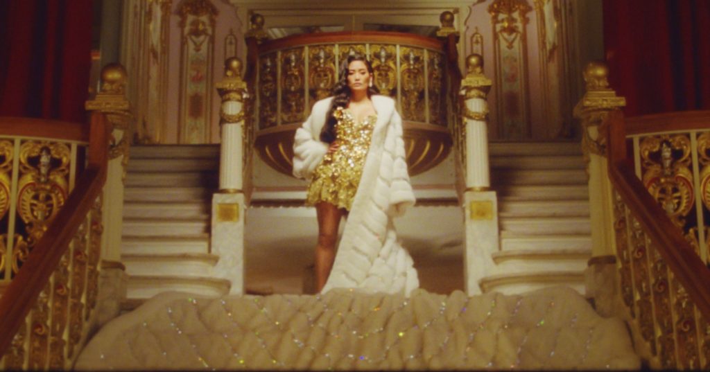 A photo of Chloe Flower at the top of a grand staircase from the video for Carol of the Bells.