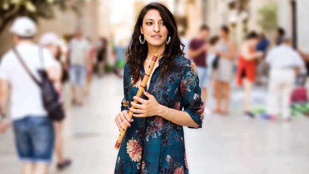 A promotional photo of Rasika Shekar holding a flute.