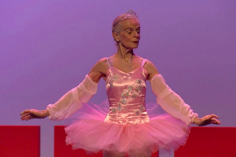 A photo of Madame Suzelle Poole in costume, on stage during a performance.