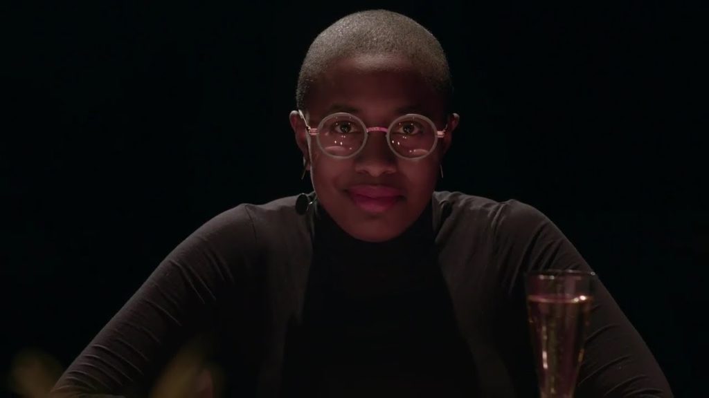 A photo of Cécile McLorin Salvant staring straight into the camera with a half smile on her face.