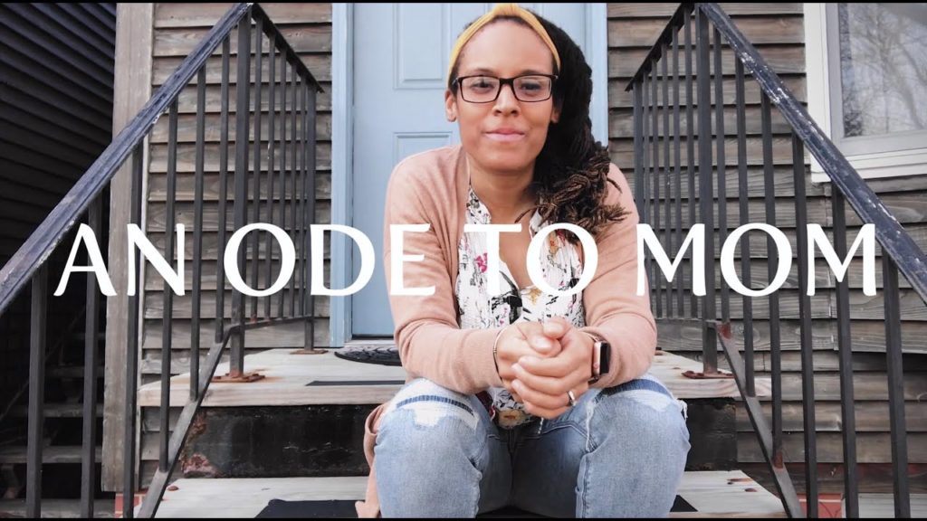 A photo of Shawndra Lucas, sitting on the steps to a house, smiling into the camera. The words "An Ode to Mom" are written across the photo in white letters.