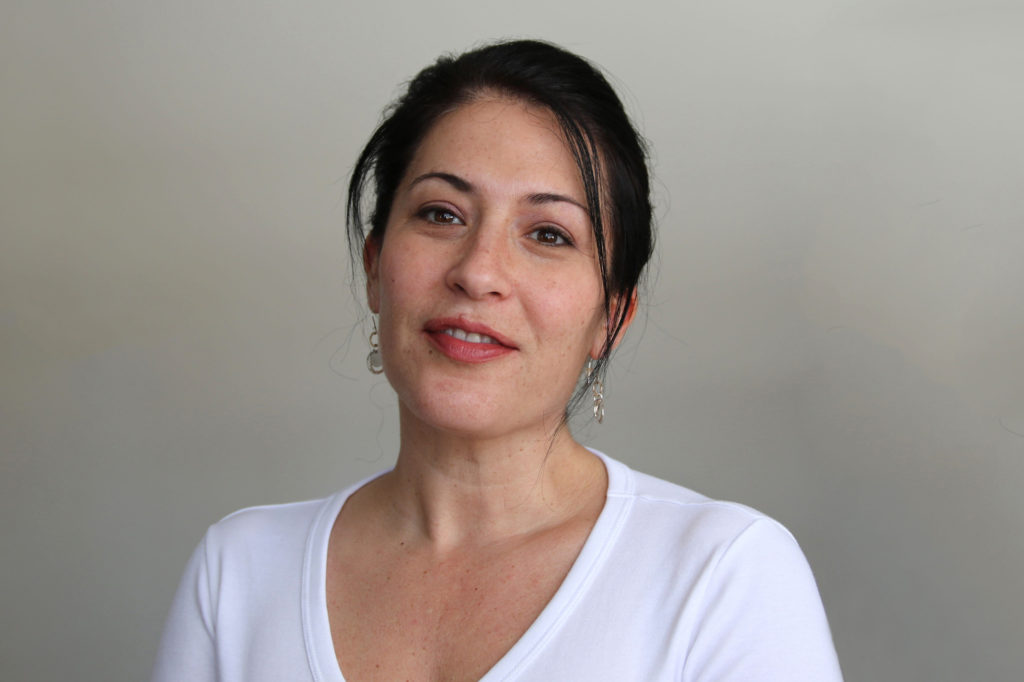 A close up photo of poet Ada Limón smiling straight into the camera.