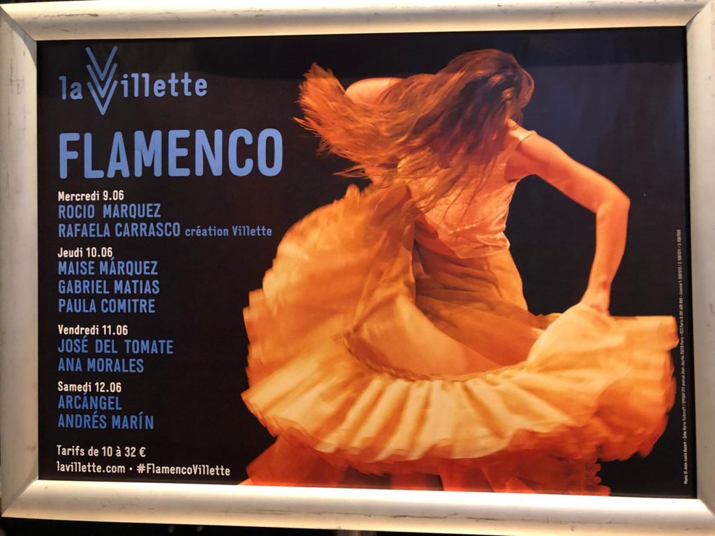 A photo of a poster for a Flamenco performance with a woman wearing an orange flamenco dress.