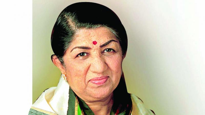 A close up photo of singer Lata Mangeshkar smiling directly into the camera.