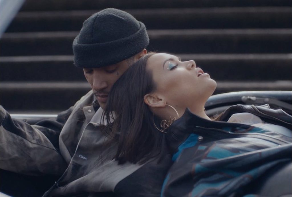 A photo of Sinead Hartnett leaning against the actor from the music video for Be the One.