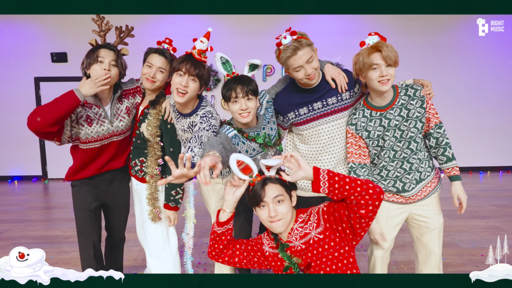 A photo of BTS dressed in Christmas sweaters from their holiday remix of Butter.