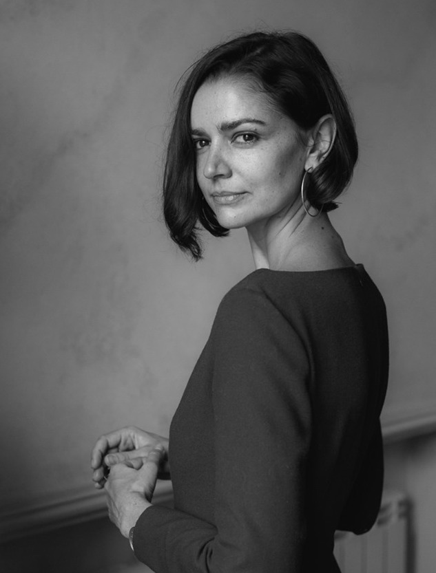 A black and white photo of Lyuba Yakimchuk looking over her shoulder at the camera