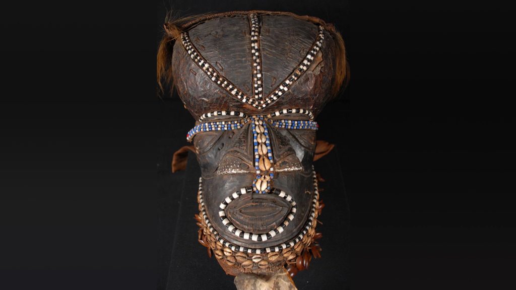 A photo of a Kuba masquerade mask depicting the figure out Woot from Kuba mythology.
