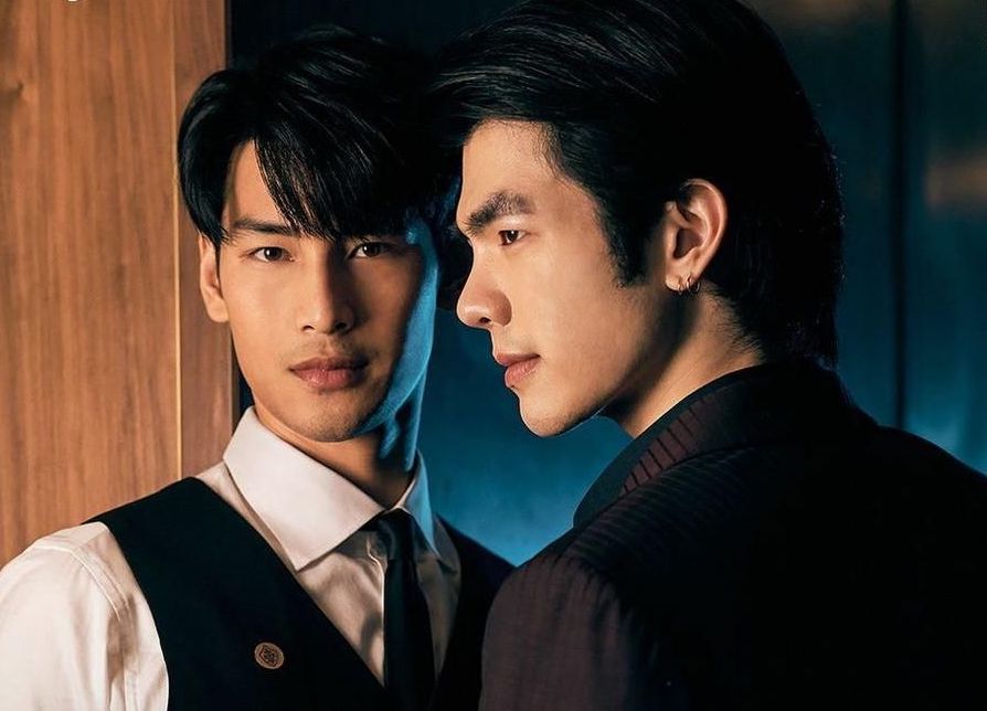 A promotional photo from the TV series KinnPorsche. It is a close of shot of lead actors Mile and and Apo. Mile is looking directly into the camera, while Mile is in profile.