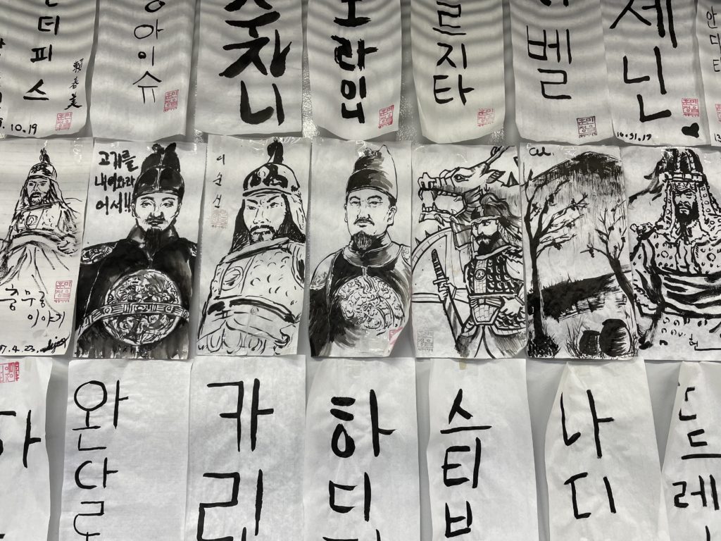 A close up photo of black and white drawings of Korean historical figures and words written in Hangul. Artists unknown.