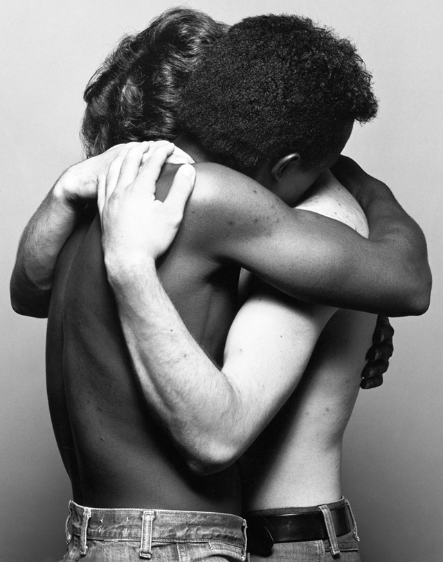 A black and white photo by Robert Mapplethorpe of two men hugging.