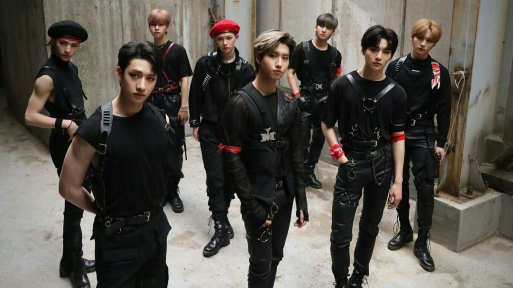 A promotional photo of Stray Kids. All eight members are posed in a group and looking straight at the camera.