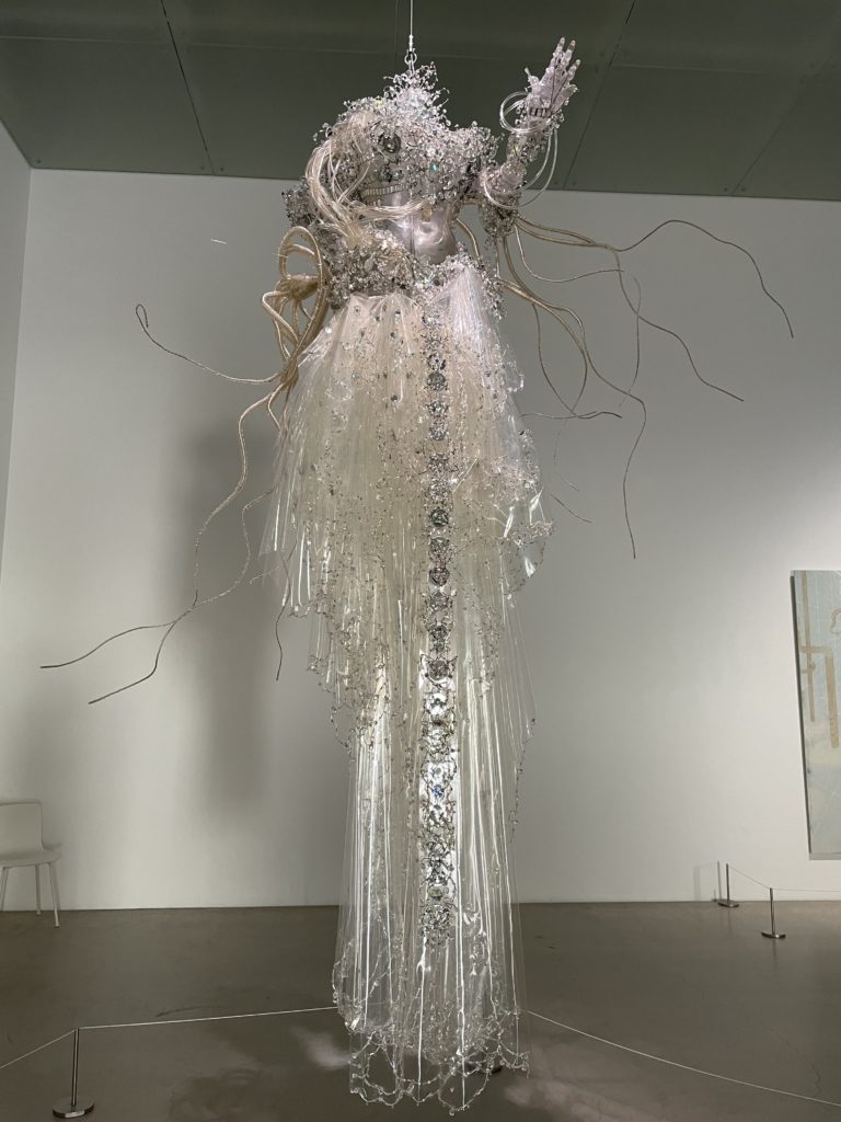 A photo of Apparition by Lee Bul. It shows an artistic sculpture of a white dress hanging in the air.