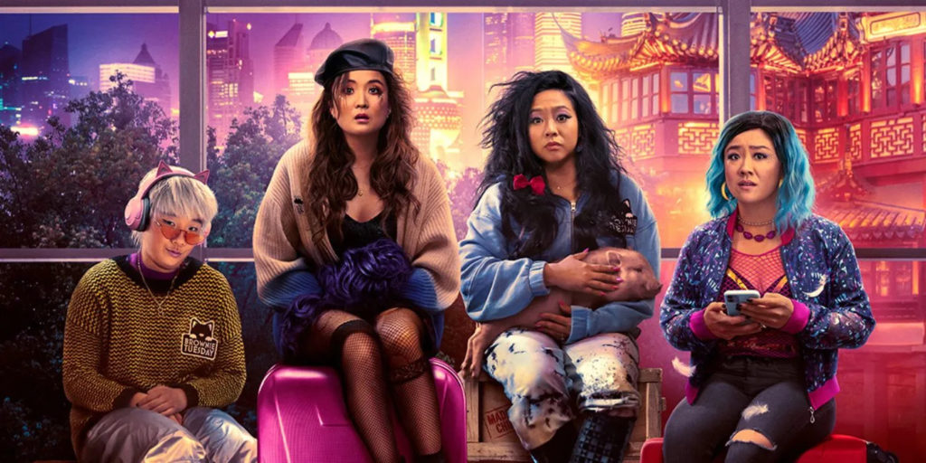 A promotional image for the film Joy Ride. It shows four women sitting in a row on suitcases, their hair all frazzled and their faces looking shellshocked.