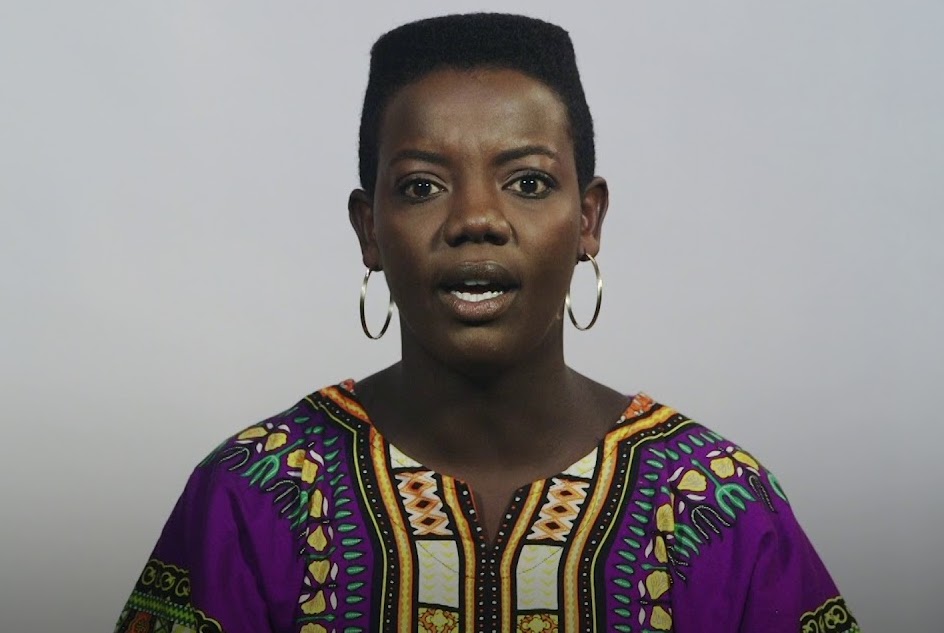 A photo still from Daily Helping for July 15th, 2023 - Immigrant Explains Difficulty Assimilating To Culture That Constantly Reboots Film Franchises. A Black woman is speaking directly into the camera against a blank background.