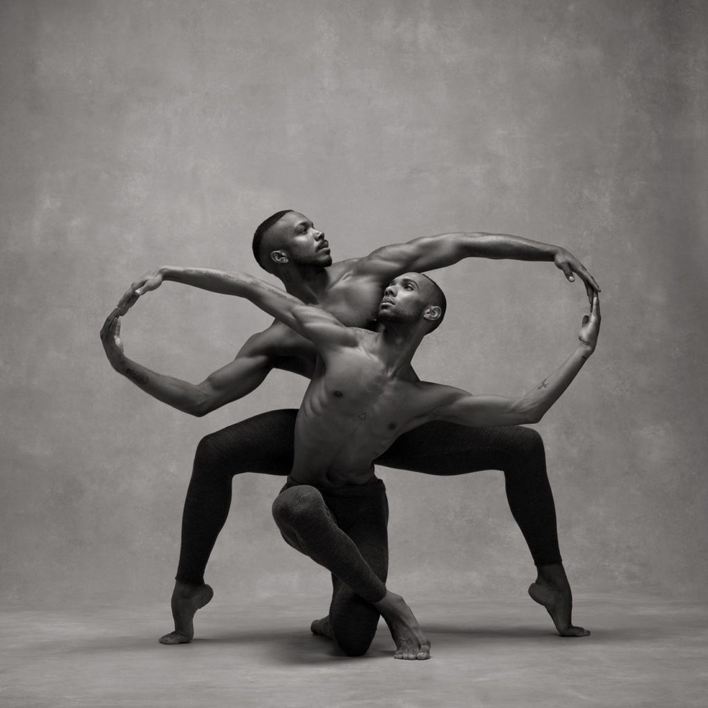 A photograph by Ken Browar and Deborah Ory. It shows dancers Michael Jackson Jr. and Sean Aaron Carmon, one behind the other, their arms linked to form an infinity symbol.