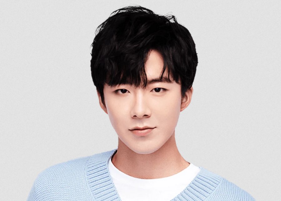 A close up photo of Liu Yu Ning from the shoulders up. He is looking straight into the camera against a white background.