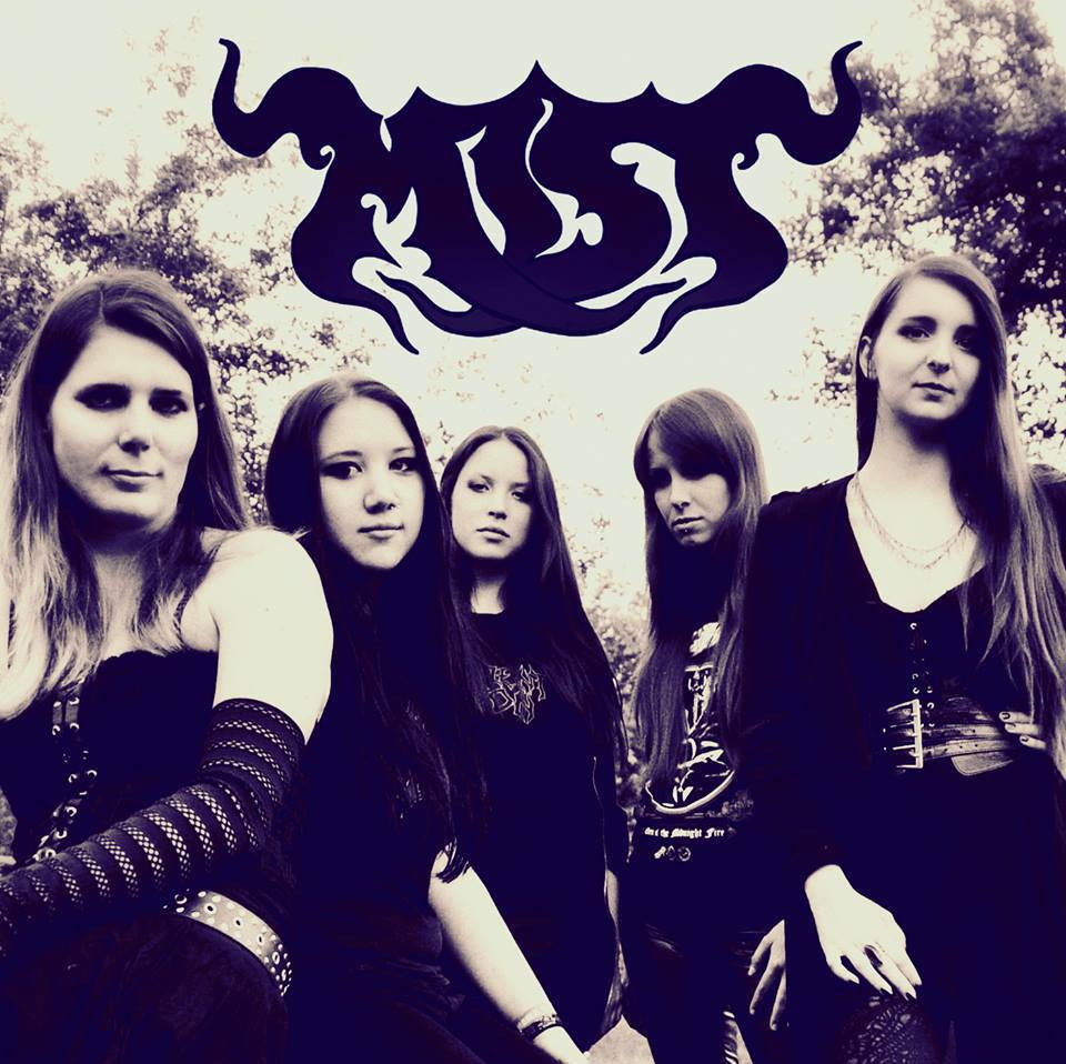 A black and white photo of the five band members of MIST. They are standing in a line, looking straight into the camera. The word MIST is superimposed in the air above them in a flowing script.